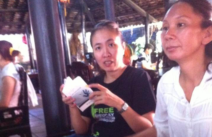 Nha Trang, May 5th 2013: Blogger Me Nam (Nguyen Nhu Quynh) and her friends discussing the Declaration of Human Rights in a coffee shop.